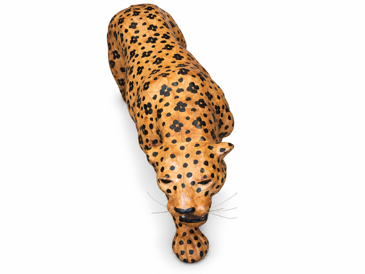 Spotted tan leather cheetah sculpture on a white background